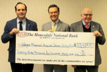 Three men holding a check